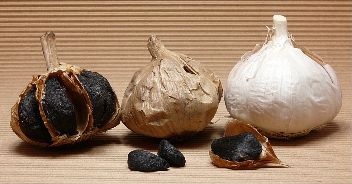 schwarzer knoblauch knollen und einzelne zehen